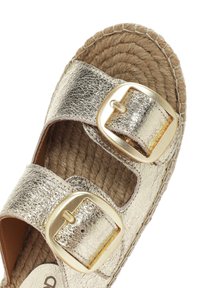 Gouden metallic leren sandaal met twee brede banden, elk met een grote metallic gesp, en een geweven jute zool. Geprofileerde leren afwerking.