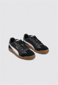 Sneaker nere realizzate in una combinazione di materiali in pelle e camoscio, con un design a strisce bianche e grigie e una suola in gomma.