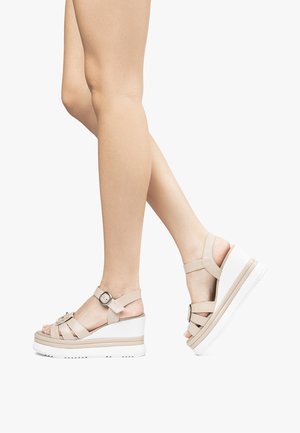 Beige sleehak sandalen met meerdere bandjes, gespdetail en een dikke witte zool. Heeft een gladde textuur en een verhoogd plateauontwerp.