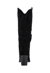 Botas de cowboy de ante negro con puntera puntiaguda, acentos texturizados y un tacón alto y cuadrado. Cuentan con costuras decorativas y un lazo en la parte trasera.