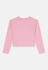Langermet, cropped topp i myk rosa bomull. Har rund halsringning og enkel, rett hem. Glatt tekstur uten mønstre eller detaljer.