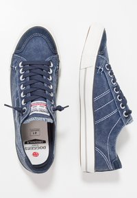 Denim sneakers in dark blue with white rubber sole and accents. Features matching laces, stitching details, and a logo tag inside.