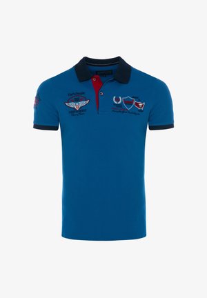 Blå kortærmet polo med sort krave, rød knapliste og broderede logoer og tekst på bryst og ærme.