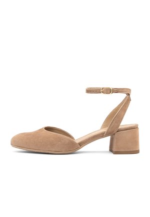 Beżowy zamszowy but na niskim obcasie typu słupek, z zamkniętym, zaokrąglonym noskiem, odkrytymi bokami oraz regulowanym paskiem wokół kostki z złotą klamrą.