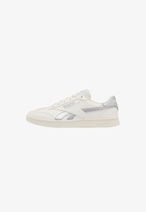Sneaker bianca Reebok low-top con accenti argento, chiusura con lacci e dettagli con marchio sul lato e sul tallone.