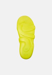 Infradito gialli in gomma con una forma sagomata, doppie cinghie e il numero 42 impresso sulla soletta, progettati per comfort e supporto.