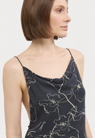 Camisole noire à fleurs avec des bretelles fines, décolleté en cowl et contours de fleurs en crème légère. Texture lisse avec une coupe drapée.