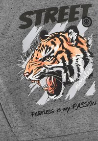 Grauer Sweatshirt mit einem großen grafischen Motiv eines brüllenden Tigers mit orangefarbenen und schwarzen Streifen, begleitet von dem Text "Fearless is my PASSION."