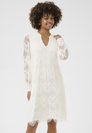 Spitzenkleid in Weiß mit V-Ausschnitt und langen Ärmeln, mit gewelltem Saum und floralem Muster. Weiches, strukturiertes Material mit transparenten Akzenten.