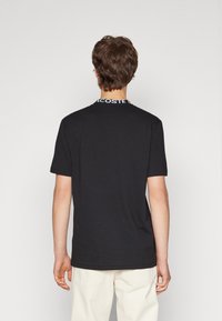 Lacoste CORE ACTIVE - Nyomott mintás póló - black