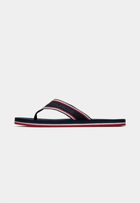 Navy flip-flop with a rubber sole, textile strap featuring red and white stripes, and "HILFIGER" logo. Minimalist design and lightweight construction.