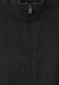 Maglione zip-up nero con colletto alto, motivo a maglia testurizzato e pannelli inferiori lisci, dotato di una zip centrale e un branding sobrio.