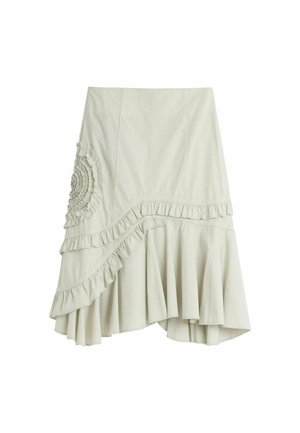 Kremasta asimetrična suknja s naboranim rubom i okruglim detaljem od skupljene tkanine na lijevoj strani, s mekanim, lepršavim rubom.