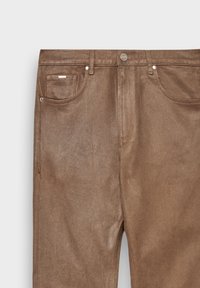 Jeans in denim marrone con una texture liscia e lucida. Le caratteristiche includono una tasca frontale, chiusura con bottone e dettagli di cucitura sottili.