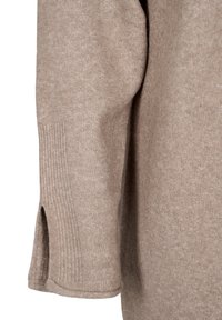 Manche de pull beige en tricot avec un détail côtelé près du poignet et une petite fente au niveau du poignet.
