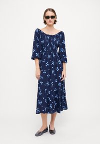 Marineblå blomster midi-kjole med avtakbar halslinning, samlet liv, trekvart ermer og lagdelt kant. Kombinert med svarte leiligheter.