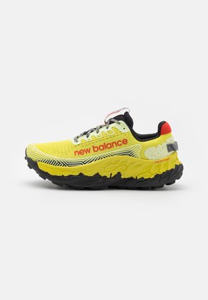 Yellow running shoe with black accents, textured mesh upper, reinforced heel, and visible cushioning in the sole. Features red branding.