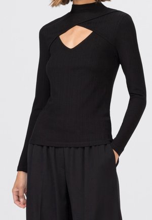 Haut à manches longues noir à côtes avec un col haut et un détail découpé, présentant un design ajusté et une texture lisse.