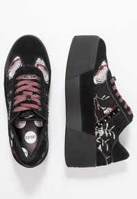 Svarta mocka plattformssneakers med broderade blommönster, texturerade detaljer och burgundy snören. Sidovyn visar nitar och kontrasterande material.