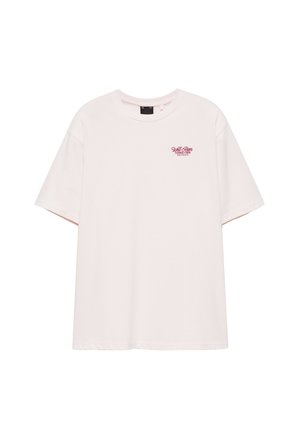 T-shirt rose clair à manches courtes avec un col rond et un petit texte rouge "Well River Tennis Club" sur la poitrine gauche.