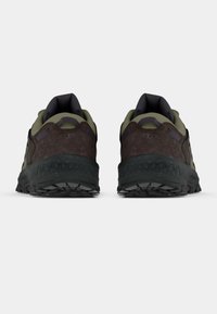 Hnědé a zelené turistické boty s texturovaným nubukovým svrškem, polstrovaným límcem a robustní černou gumovou podrážkou.