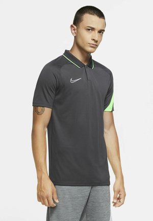 Nike Polohemd in Schwarz mit grünen Akzenten, kurzen Ärmeln und Kragen-Design. Mit einem weißen Logo auf der linken Brust.