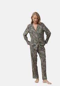 Schwarzes und weißes, zebra-gestreiftes Schlafanzug-Set, bestehend aus einem Langarmhemd mit Knopfleiste und V-Ausschnitt sowie geraden Hosen. Glatte Stofftextur.