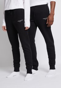 Schwarze Sweatpants mit schlankem Schnitt, mit einem Kordelzugbund und gesticktem "TOMMY HILFIGER"-Logo auf der Vorderseite.