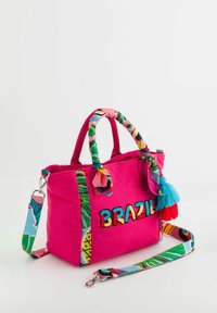 Vaaleanpunainen kangaskäsilaukku, jossa on värikäs brodeeraus "BRAZIL". Sisältää eläväisiä, kuvioituja hihnoja ja sinisen tupsuakorin.