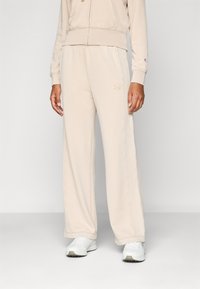Beiga bomullsblandade sweatpants med en bred ben-design. Har stickade detaljer och en broderad logga på sidan.