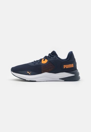 Mørkeblå Puma løbesko med orange accenter og hvid sål, vist i siddevisning på en ensartet lys baggrund.