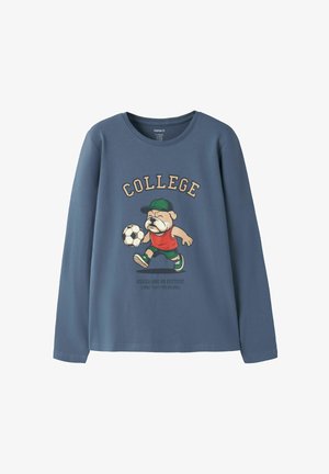 Chemise bleue à manches longues avec un chien de dessin animé portant une casquette et jouant au football, texte "COLLEGE" au-dessus et petit texte sous le chien.