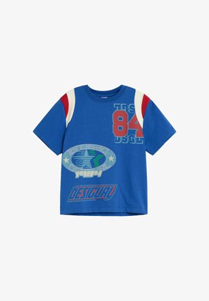 T-shirt blu a maniche corte con strisce rosse e bianche sulle spalle, caratterizzata da stampe che includono "84", un emblema a stella e il logo "Desigual".
