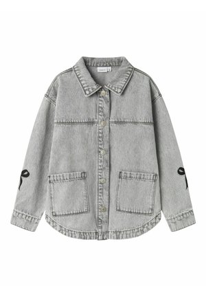 Veste en jean gris clair avec boutons à l'avant, deux grandes poches devant, col et nœuds brodés noirs sur les deux manches.