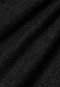 Schwarzer Strickstoff mit weicher, strukturierter Oberfläche. Er weist ein geripptes Muster und dezente Schattierungsvariationen auf.