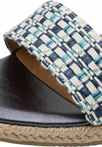 Sandale tissée avec une bride bleu, blanc et argent sur une base en cuir marron foncé ; semelle texturée de style espadrille.