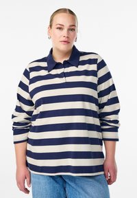 Polo majica z dolgimi rokavi, ki ima horizontalne črte v mornarsko modri in kremni barvi, ovratnik in sproščen kroj. Blago iz mešanice bombaža z mehko teksturo.