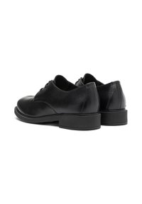 Scarpe in pelle nera con una finitura liscia, punta arrotondata e tacco basso. Presentano lacci e dettagli di cucitura discreti sul tacco.