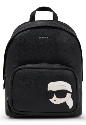 Schwarzer Rucksack aus strukturiertem Leder mit Fronttasche, versehen mit einem stilisierten Gesicht, das schwarze Sonnenbrillen trägt, und einem weißen Haargummi-Detail.