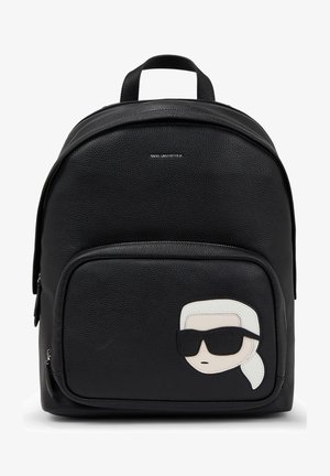 Czarny teksturowany skórzany plecak z przednią kieszenią, z motywem stylizowanej twarzy w czarnych okularach przeciwsłonecznych i białym tasiemkowym akcentem we włosach.