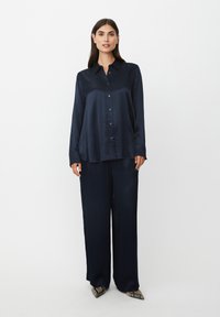 Navyblaues Satinoberteil und weite Hosen im Set. Verfügt über eine knöpfbare Vorderseite, lange Ärmel und eine glatte, glänzende Textur.