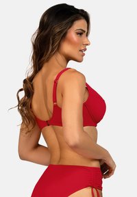 Czerwone bikini z teksturowanej tkaniny, regulowanymi ramiączkami i złotymi akcentami. Posiada podtrzymującą konstrukcję i wiązania po bokach majtek.