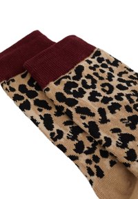 Ponožky s leopardím vzorom na béžovom základe, s čiernymi škvrnami a vínovým rebrovaným lemom. Vyrobené z mäkkého pleteného materiálu.