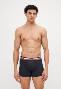 Fekete boxer alsónadrág puha, rugalmas derékkal, piros és kék csíkkal, az elején a "Levi's" logóval.