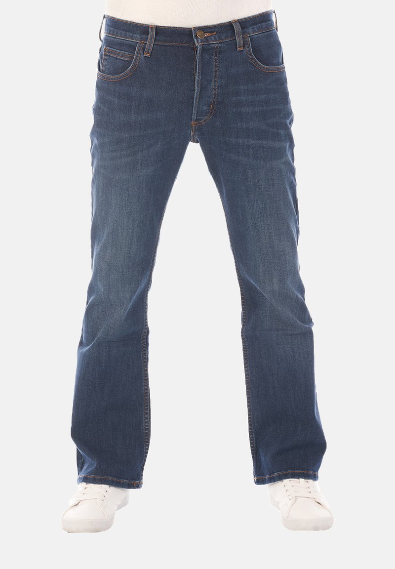 Donkerblauwe denim jeans met een rechte snit, voorzien van vijf zakken, contrasterende stiksels en een ritssluiting. Gekenmerkt door witte sneakers.