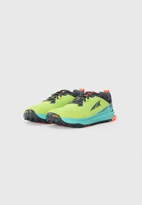 Une paire de chaussures de trail de couleur vert lime avec des lacets noirs, des semelles intermédiaires turquoise et des languettes de talon orange sur un fond blanc.
