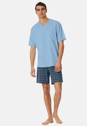 Hellblaues V-Ausschnitt T-Shirt mit Brusttasche, kombiniert mit marineblauen Karoshorts. Das Outfit zeichnet sich durch eine lockere Passform und einen weichen Baumwollstoff aus.