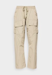 Béžové cargo kalhoty s elastickým pasem, stahovací šňůrkou a několika kapsami po stranách. Vyrobeno z lehké tkaniny.