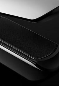 Gros plan sur une montre intelligente noire élégante avec un bracelet texturé et une surface d'écran lisse et brillante.