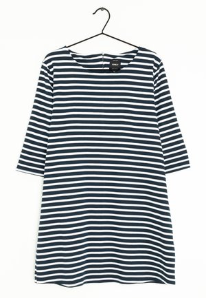 Robe rayée noire et blanche à rayures horizontales avec manches trois-quarts suspendue sur un cintre noir sur fond blanc.